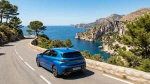 Voiture moderne circulant sur une route côtière ensoleillée surplombant la mer Méditerranée pour aller à Menton.