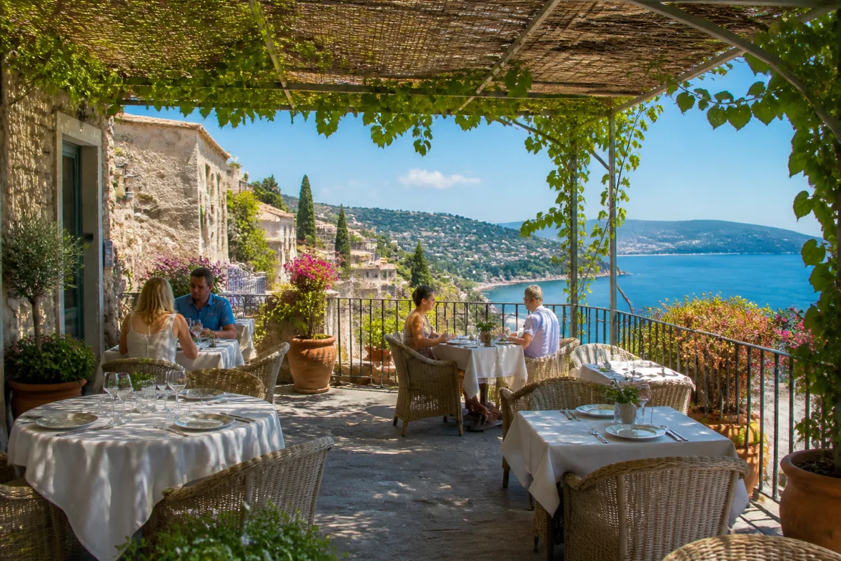 Terrasse de restaurant à Roquebrune village, tables dressées sous une ombrière avec vue sur la Méditerranée